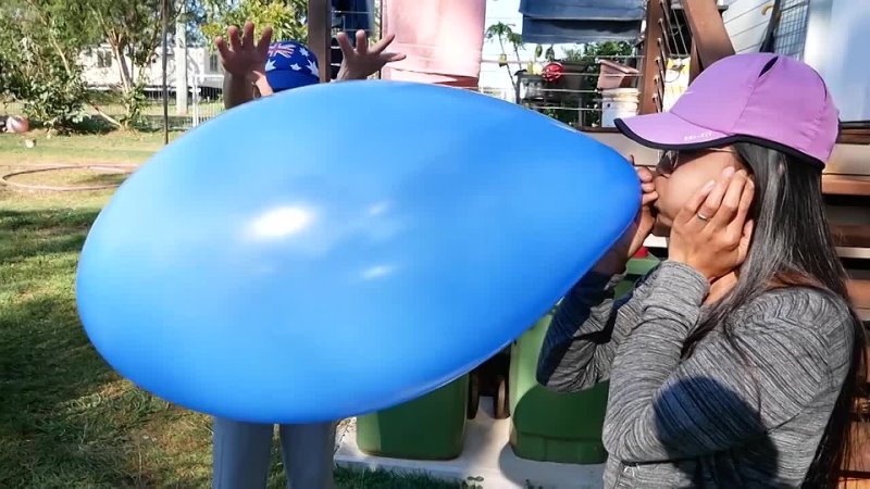 Young mom blows up a zeppelin shaped balloon until it