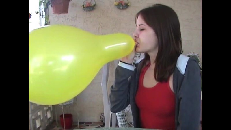 Big yellow balloon bursting by girl