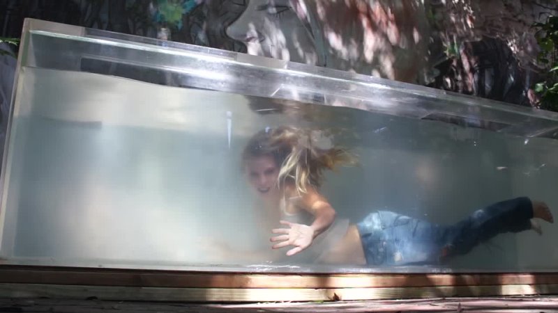 Trina Mason underwater inside her aquarium fully clothed jeans