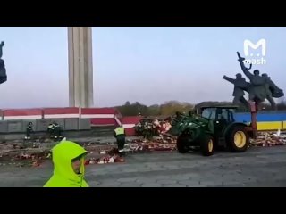 Коммунальные службы в Риге с раннего утра тракторами (!) убирают море цветов, оставленных вчера тысячами жителей у Монумента осв