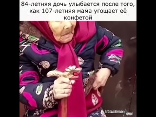 84-летняя дочь улыбается после того, как 107-летняя мама угощает её конфетой