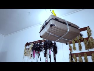 Girl tied into the suitcase with cable ties and hung the suitcase from the ceiling with chains