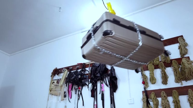 Girl tied into the suitcase with cable ties and hung the suitcase from the ceiling with