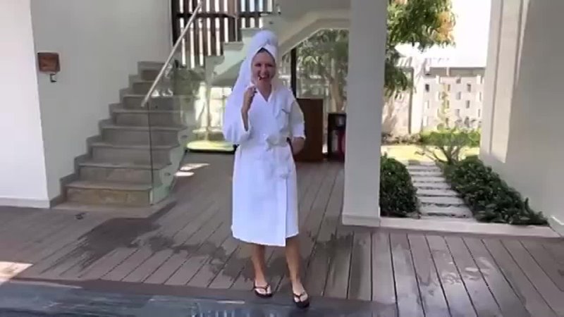 Lulu is swimming in a pool in a white bathrobe and a towel. Wetlook video in