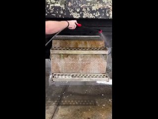 Pressure washing a metal stair.