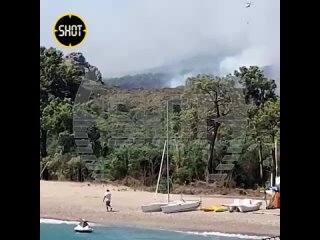 Обстановка в районе турецкого Кемера, где бушуют пожары. Туристы купаются в нескольких метрах от огня. Над пляжами и отелями с у