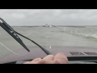 Из-за дующего второй день с Азовского моря сильного ветра вода подтопила низкие участки автодороги на Арабатской стрелке. Возле