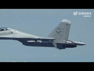 A Su-30MK2 naval aviation fighter of the PLA Navy fires off heat decoys 250 meters from a US Navy reconnaissance aircraft over t