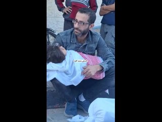 A Palestinian father from the Qandil clan bids a final farewell look at his little daughter, brutally murdered in an Israeli air