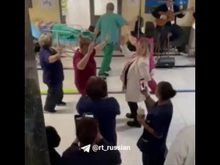 Сотрудники больницы танцуют под музыку, пока мимо везут больного на каталке в одном из медучреждений Греции