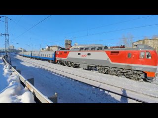Казахский поезд в Новосибирске и пассажирские поезда РЖД в солнечный зимний день. Железная дорога в Сибири. Транссиб