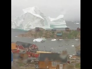 пpoxoдящий y берега огромный айсберг
