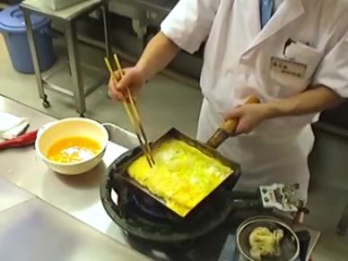 Японский шеф-повар готовит очень сложный омлет, используя большую луженую медную тамагояки (квадратную форму для яиц)