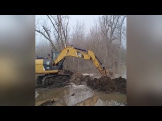 На одной из улиц Оренбурга при помощи экскаватора пытаются спасти дамбу от размыва