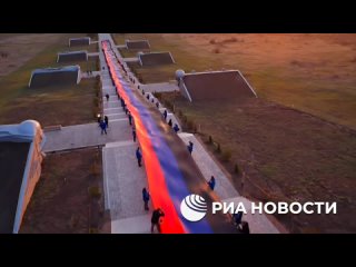 🇷🇺 Активисты молодежных организаций на мемориале “Саур-Могила“ растянули 200-метровый флаг ДНР в честь десятой годовщины со дня