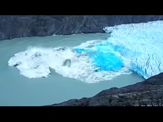 Iceberg flipping over revealing very old blue ice.