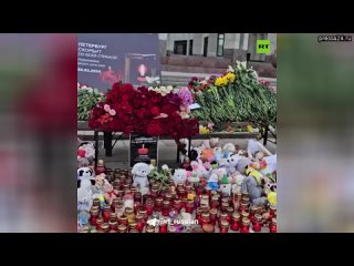 Женщина не смогла сдержать слёз, когда возлагала цветы у стихийного мемориала в Петербурге в память