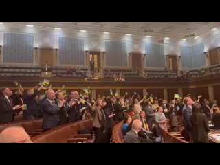 Members of Congress of combined questionable IQ enthusiastically wave blue & yellow, in a display of complete idiocy