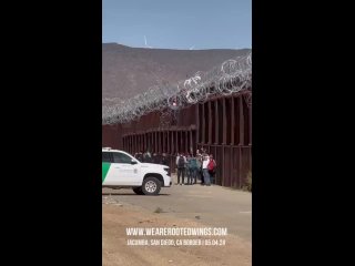 Группа нелегалов, перелезших из Мексики в США через пограничную стену в Сан-Диего, делает победное селфи на свои телефоны
