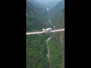 В китайском Чунцине хладнокровные водители едут над пропастью на подвесном железном мосте [ND]