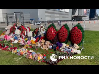 У стихийного мемориала возле Крокус сити холл в Москве собираются люди