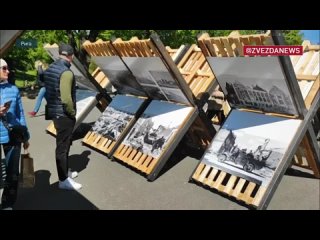 На улице в Риге открылась выставка фотографий времен Великой Отечественной войны, горожане внимательно рассматривают снимки