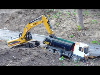 Tractor Excavator and 4 x 4 Dump Truck load stones