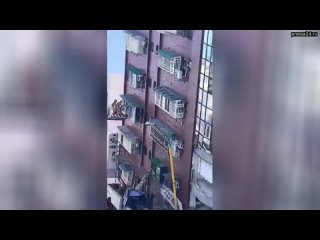 Спасатели оцепили частично разрушенное здание на Тайване и вызволяют людей с помощью пожарных лестни