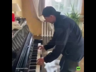 Un hombre toca el piano en una casa inundada en Rusia