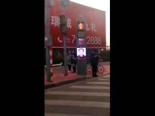 В Китае светофоры распознают пешеходов, которые идут на красный, и выводят их лица на экран для пристыжения.