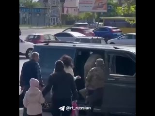 Одесские военкомы пытались затолкать в машину мужчину, пока тот истошно кричал о том, что его ребенок остался один. На форме одн