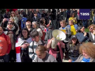 People gather for a rally in front of the entrance to the Georgian parliament building to protest against the bill on foreign ag