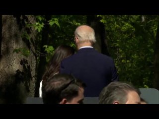 Biden leans in to chat with AOC  who then guides him off the stage, where he immediately gets confused