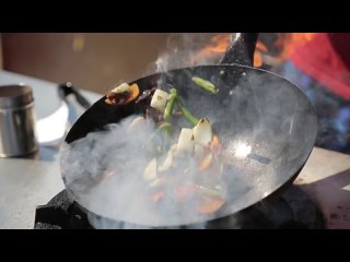 chef-cooking-with-fire-in-frying-pan-on-a-street-food-festival-free-video.mp4