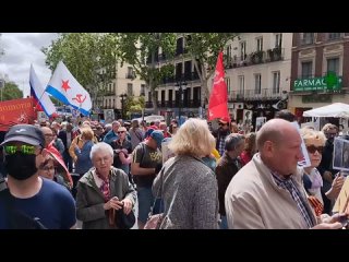 Unas  personas marchan por el centro de Madrid en el marco de un festejo adelantado por el Día de la Victoria