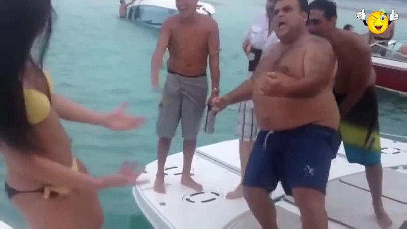 Толстый мужик учит танцевать девушку в купальнике на яхте.