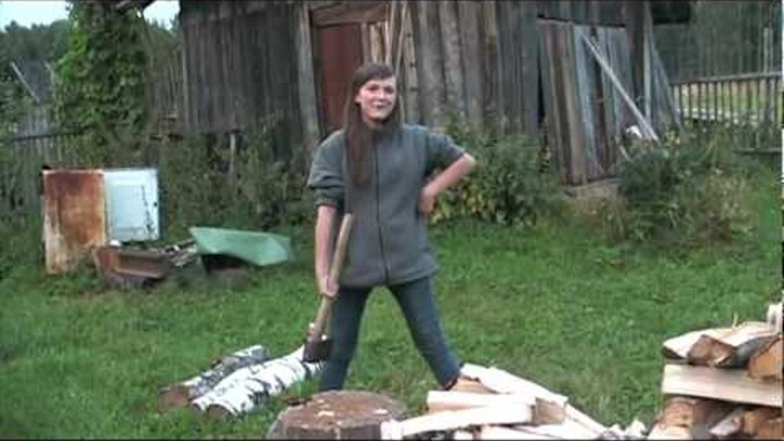 бабуля рубит дрова в деревне. заготовка дров. бабка колет дрова.