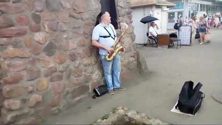 Уличный саксафонист играет в городе Королеве