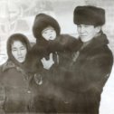 Фотография "С/з "Казахстан":мама в тулупе; Жезде (муж сестры); племянник Султан. Позади клуб и книжный магазин.Зима 1989г."