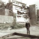 Фотография "Штатный фотограф Чернобыльской атомной электростанции Анатолий Рассказов на фоне разрушенного 4-го"