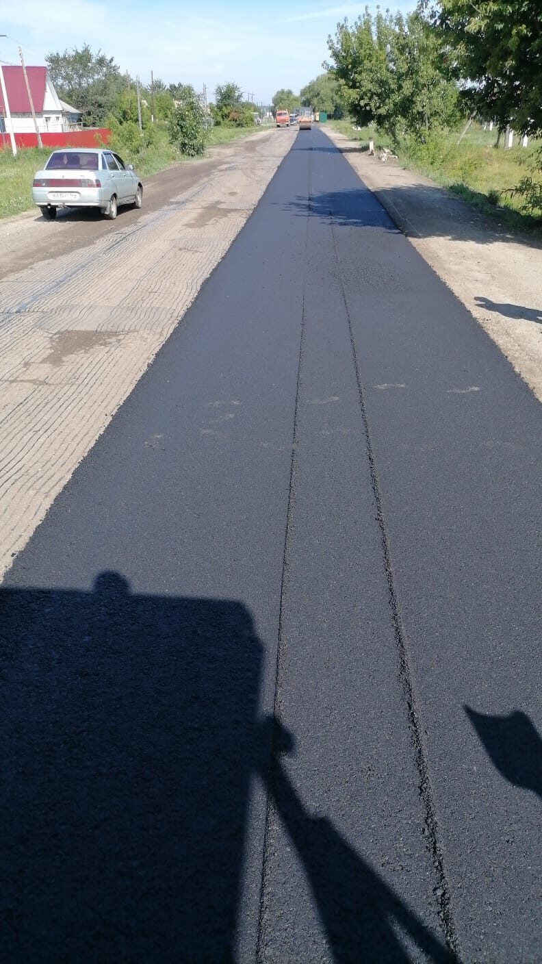 На проезжей части улицы Политотдельской в селе Озёрки ведётся укладка асфальтового покрытия