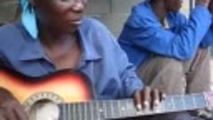 Beautiful African Woman Plays Guitar In A Slightly Non-Tradi...