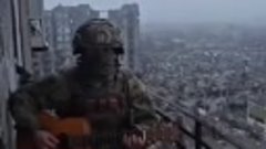 Русский солдат играет на гитаре