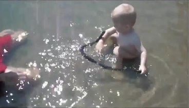 Малыш играет со змеёй