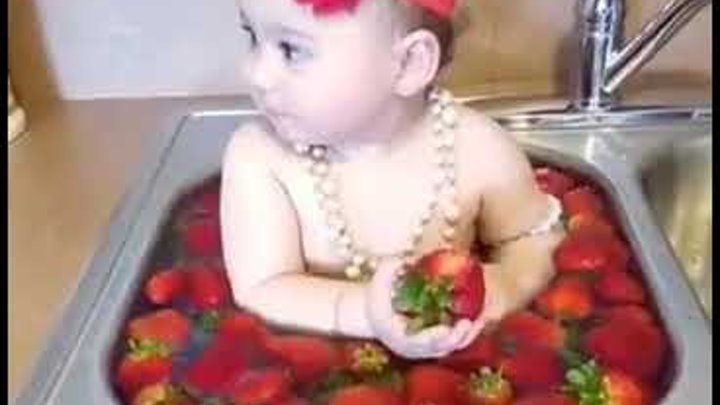 Девочка кушает клубнику в раковине