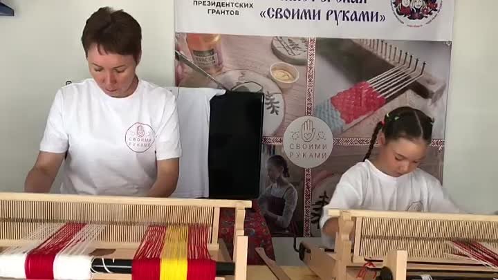 Родители и дети вместе учатся ткать на ручных ткацких станках