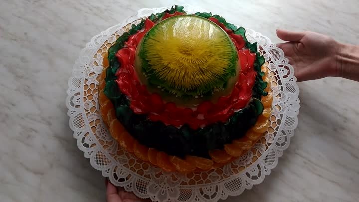 Торт оформлен прозрачными цветными фруктовыми слайсами и тортом-желе