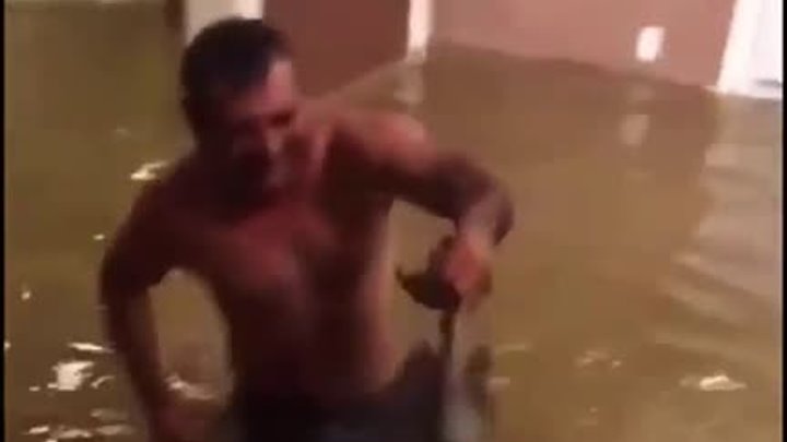 Мужчина ловит рыбу в затопленном доме