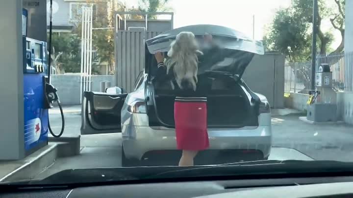 Blonde woman tries to fill up a Tesla Model S with gas