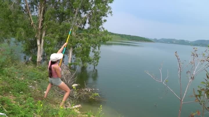 Рыболовное видео. Красивая девушка охотится на большую рыбу с традиционным